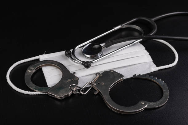 Hygienic face mask, stethoscope and handcuffs. Accessories for doctors and patients for personal protection. Dark background.